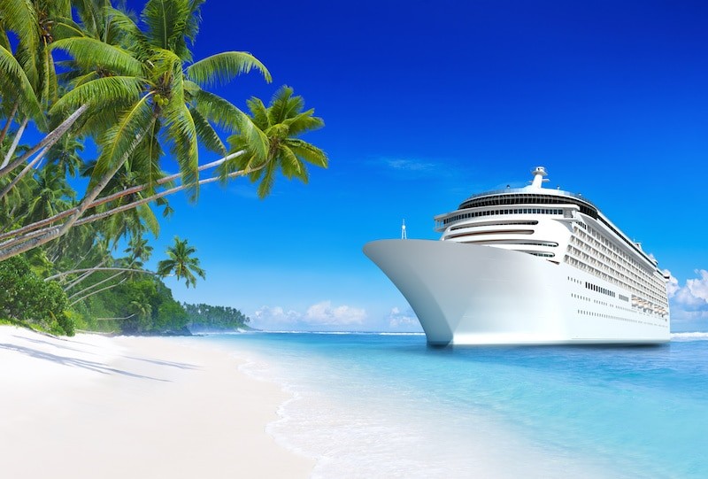 picture of a cruise ship off a white sand beach