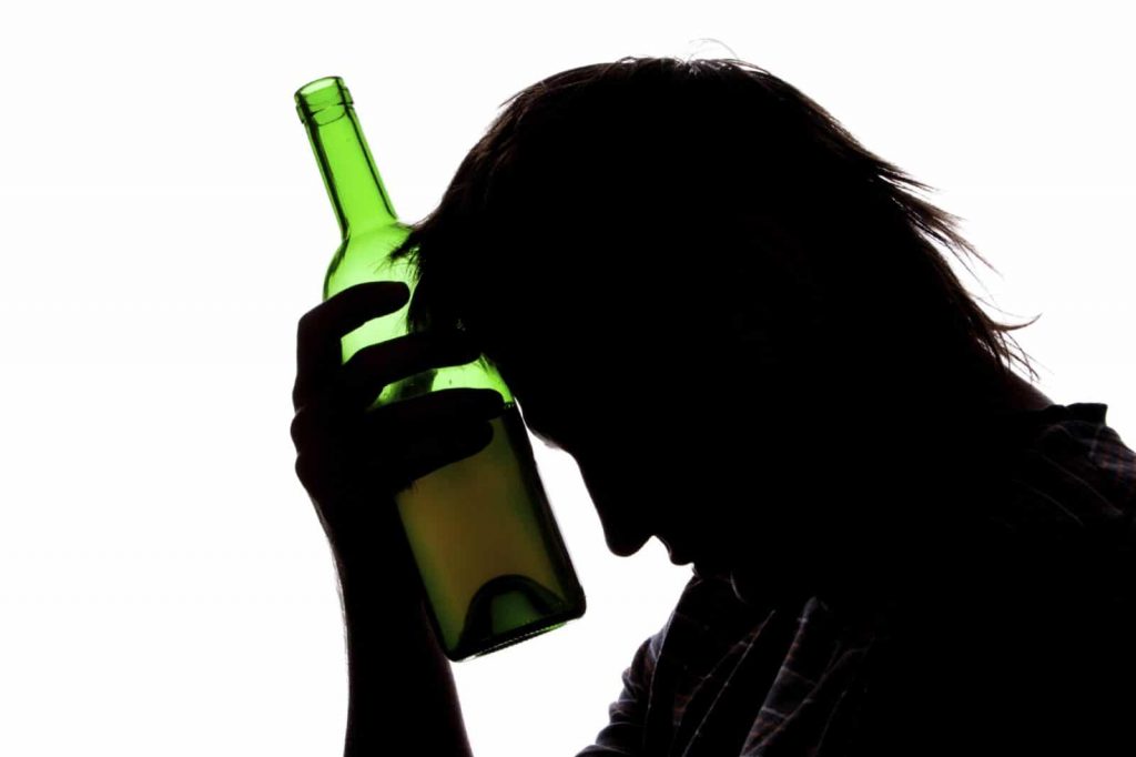 Silhouette of sad man drinking alcohol