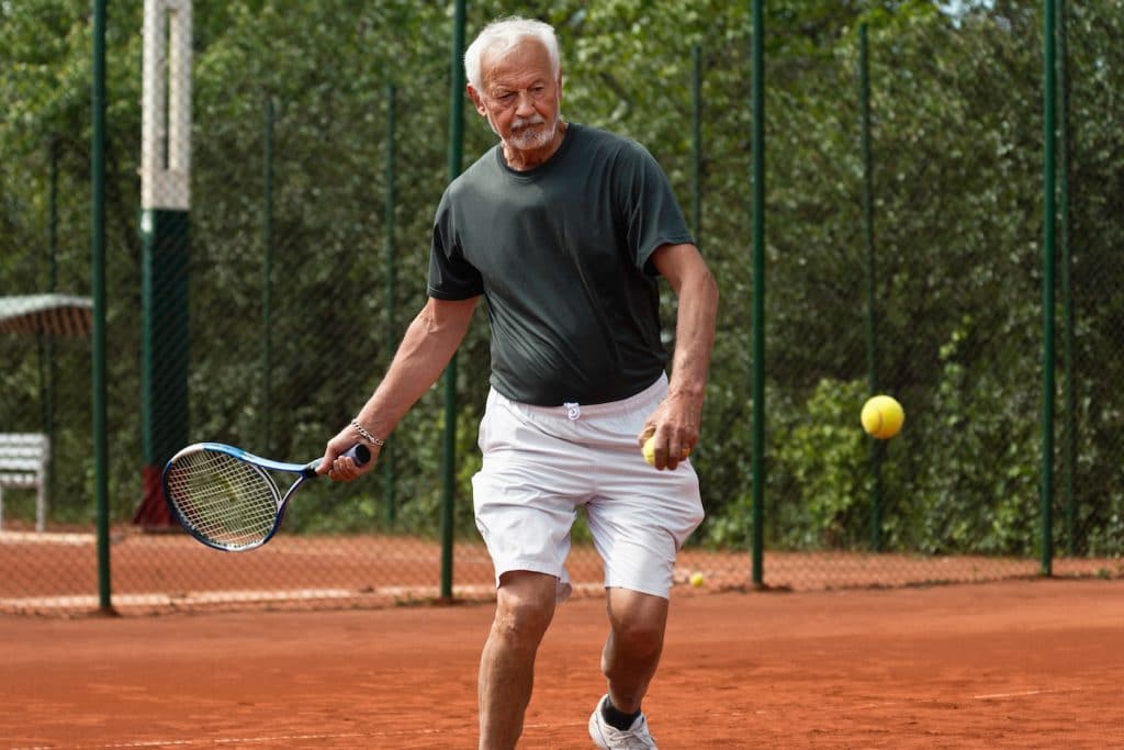 senior man playing tennis