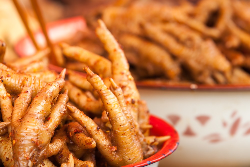 Chicken feet waiting to be eaten at the market in Xinjie, China.